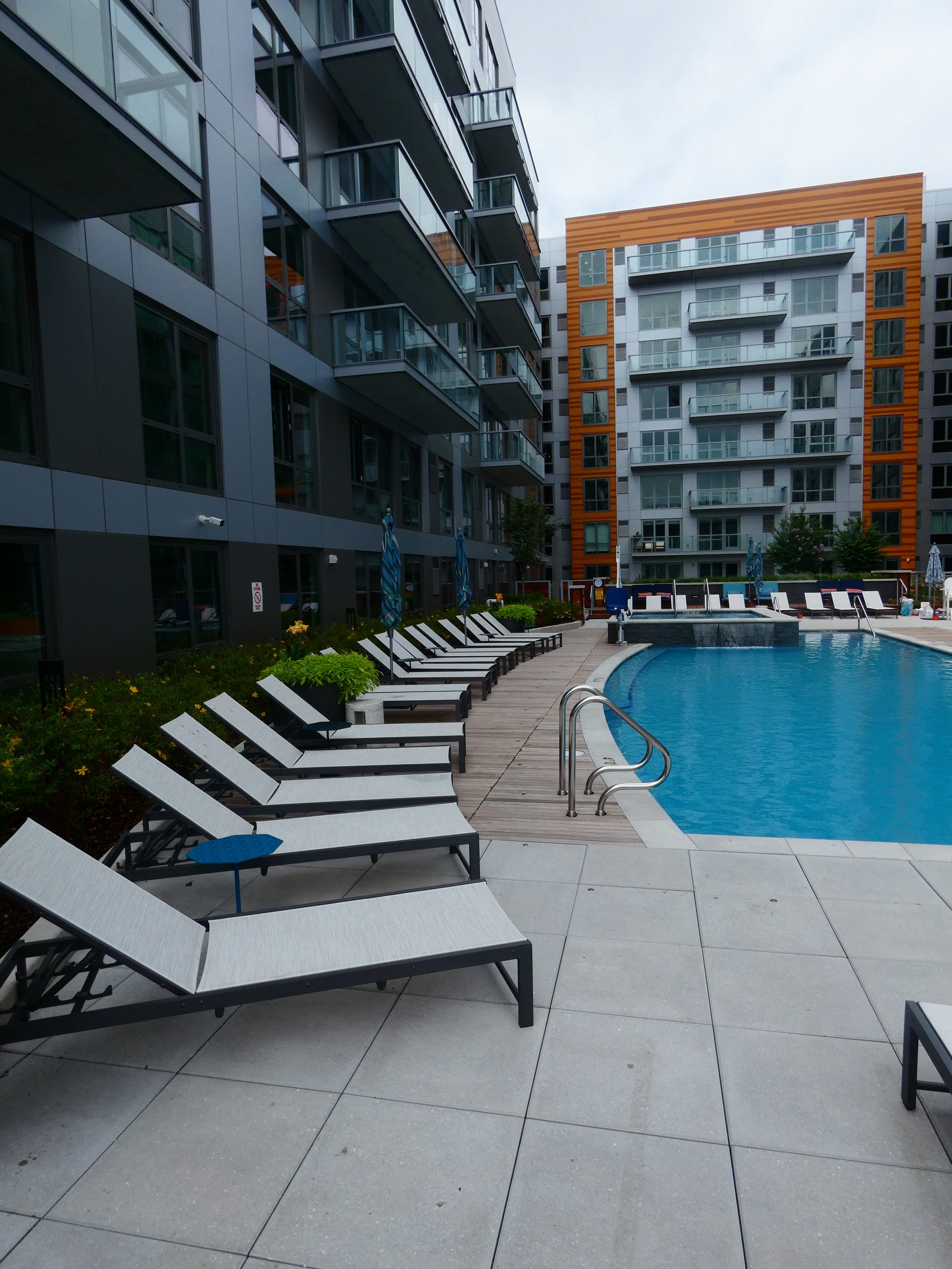 Courtyard pool deck between two finished mid-rise apartment buildings