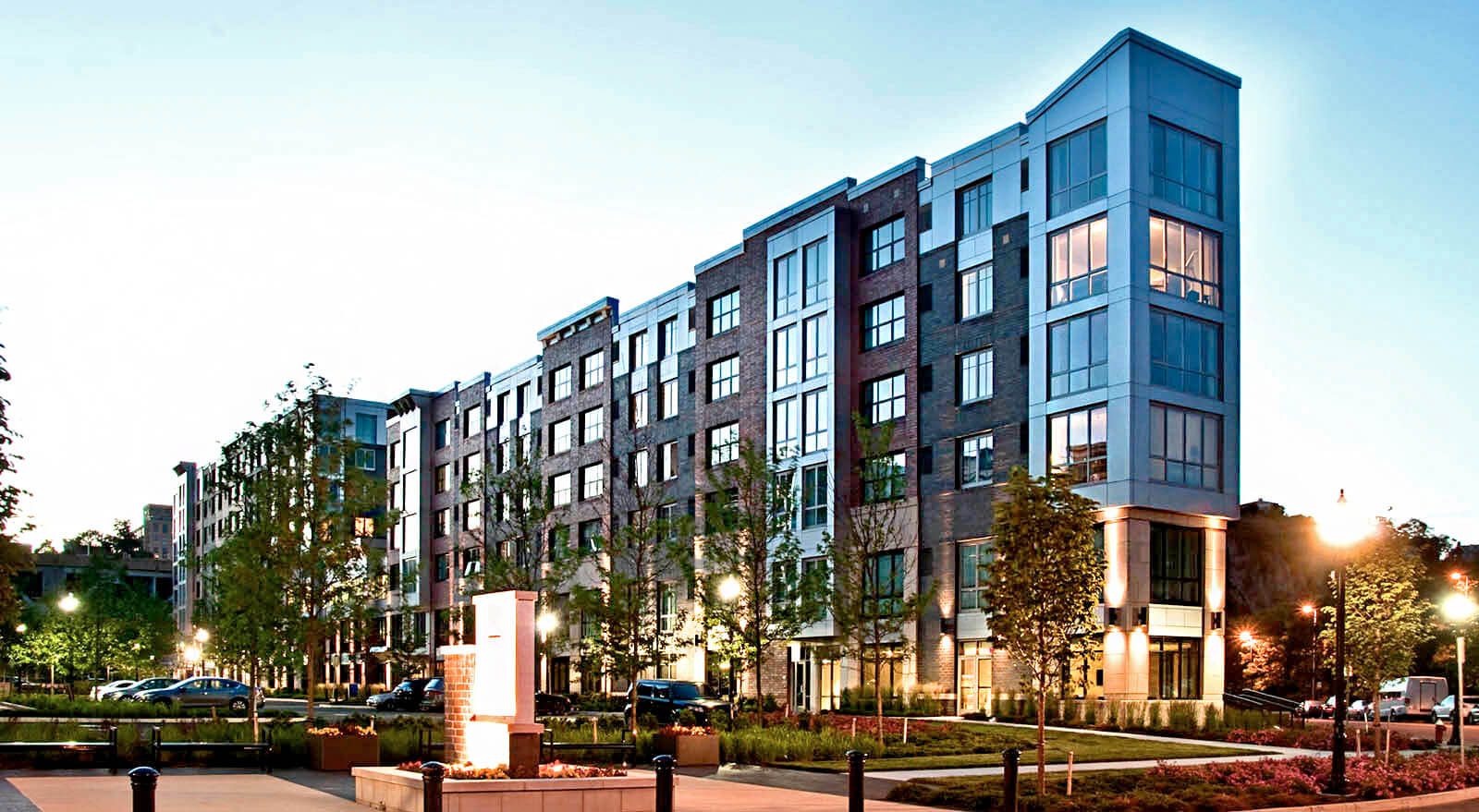New mid-rise apartment building exterior at dusk