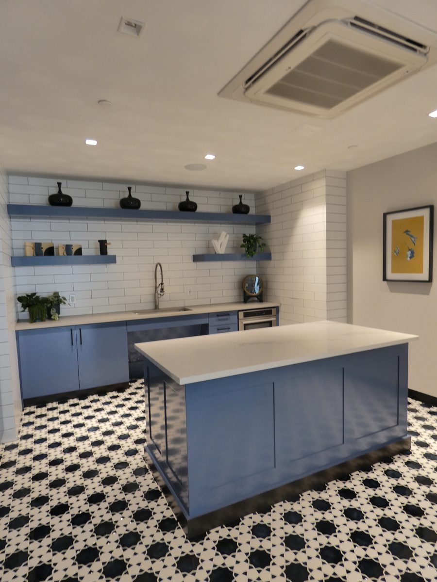 Cocina de amenidades con azulejo, estantería e isla